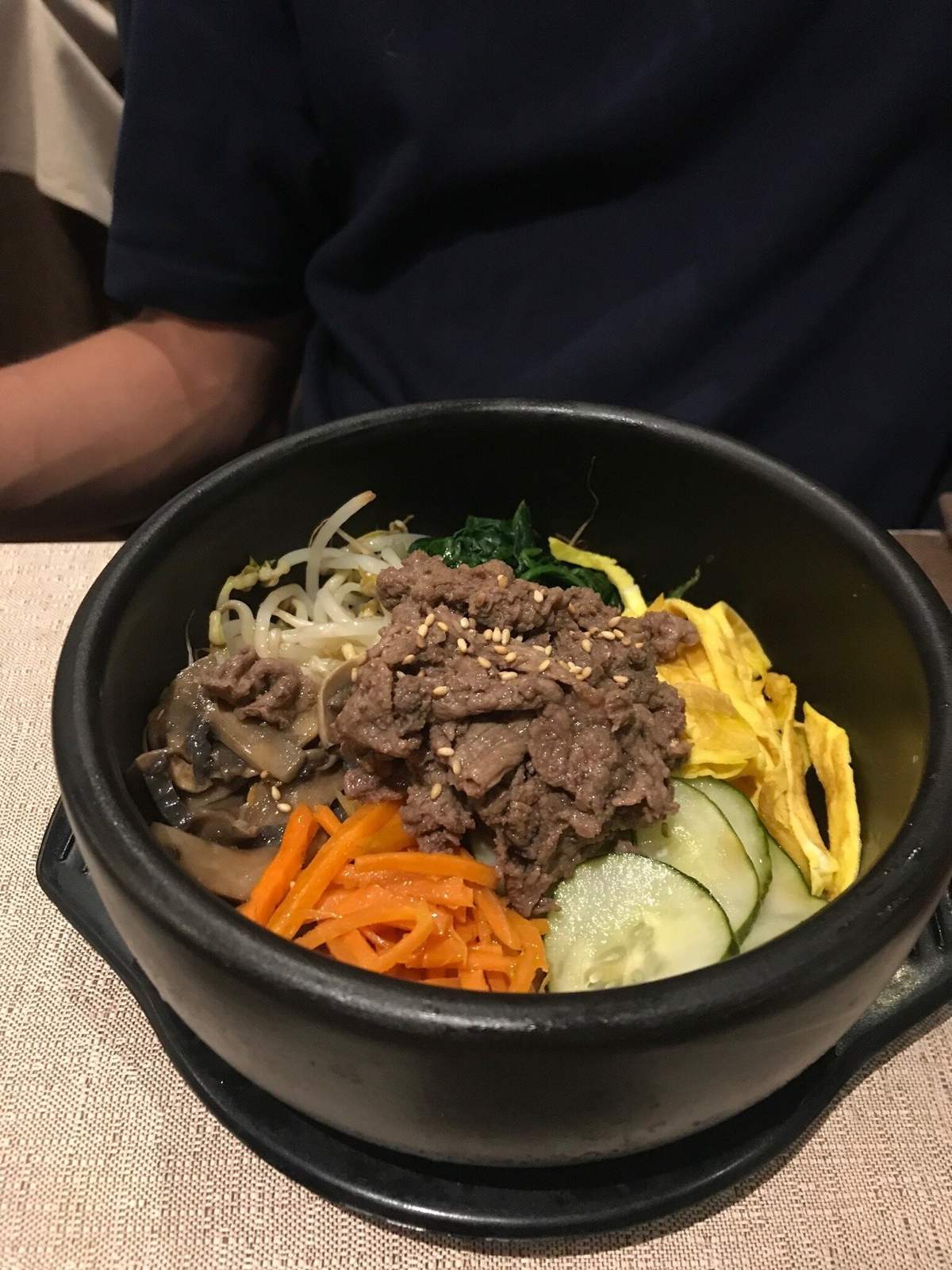 Bibimbap bulgogi nella dolsot nera con carote e cetrioli