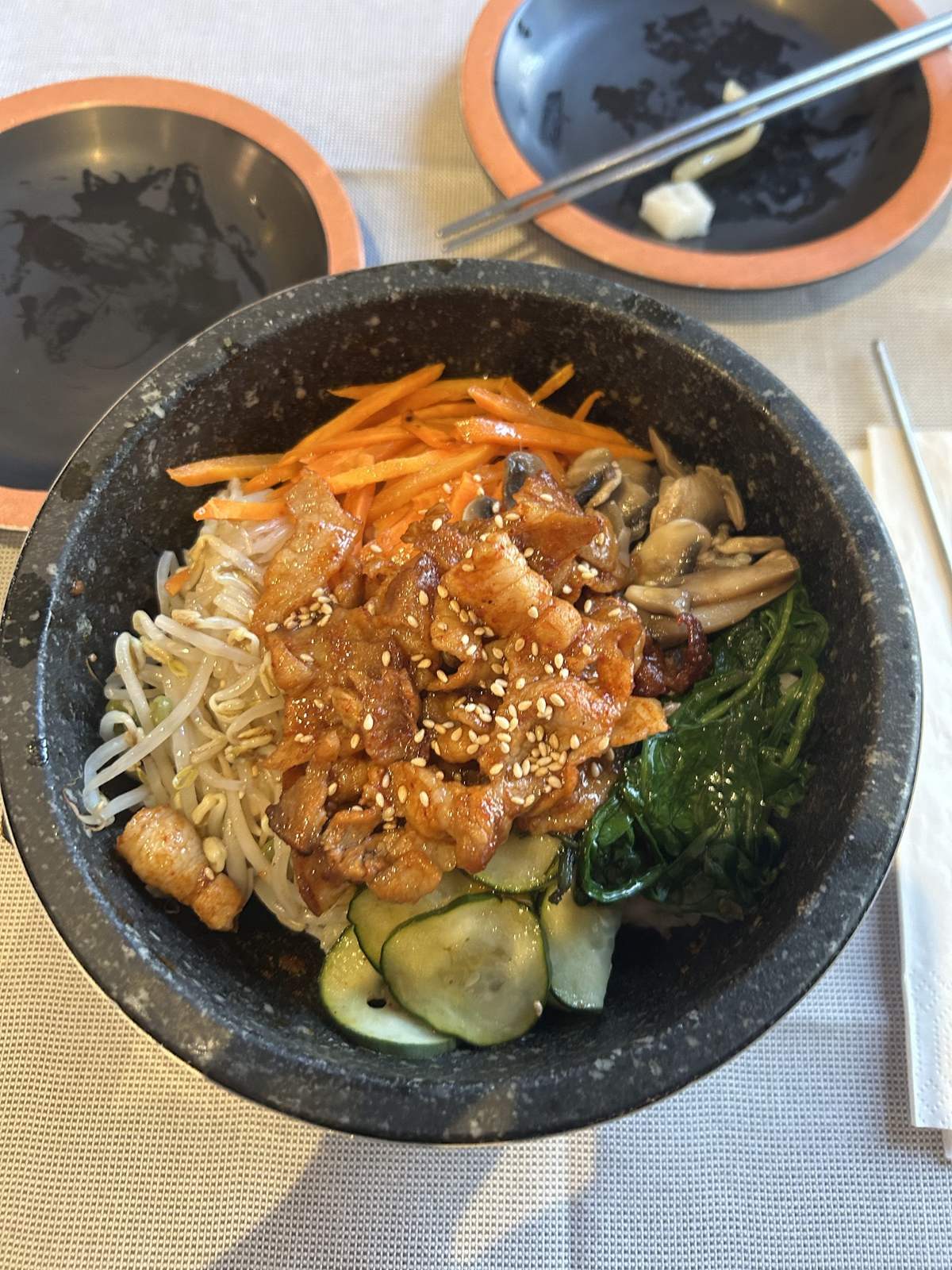 Bibimbap jeyuk con pancetta piccante e sesamo nella ciotola di pietra