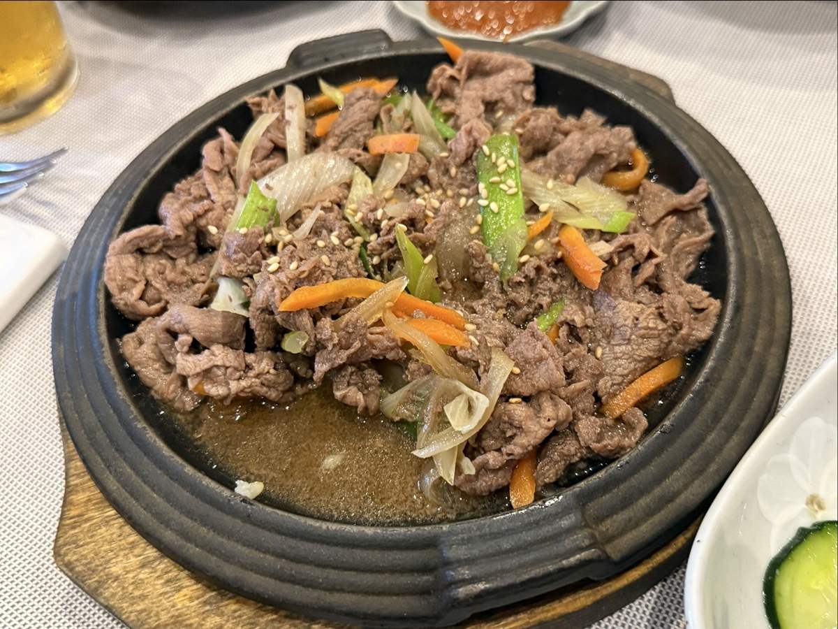 Bulgogi di manzo con cipollotti e carote sulla piastra di ghisa
