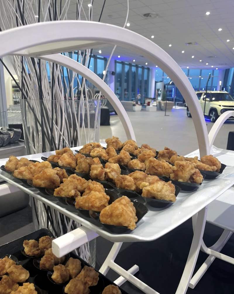 Bocconcini di pollo fritto coreano su cucchiai neri, sul vassoio del buffet