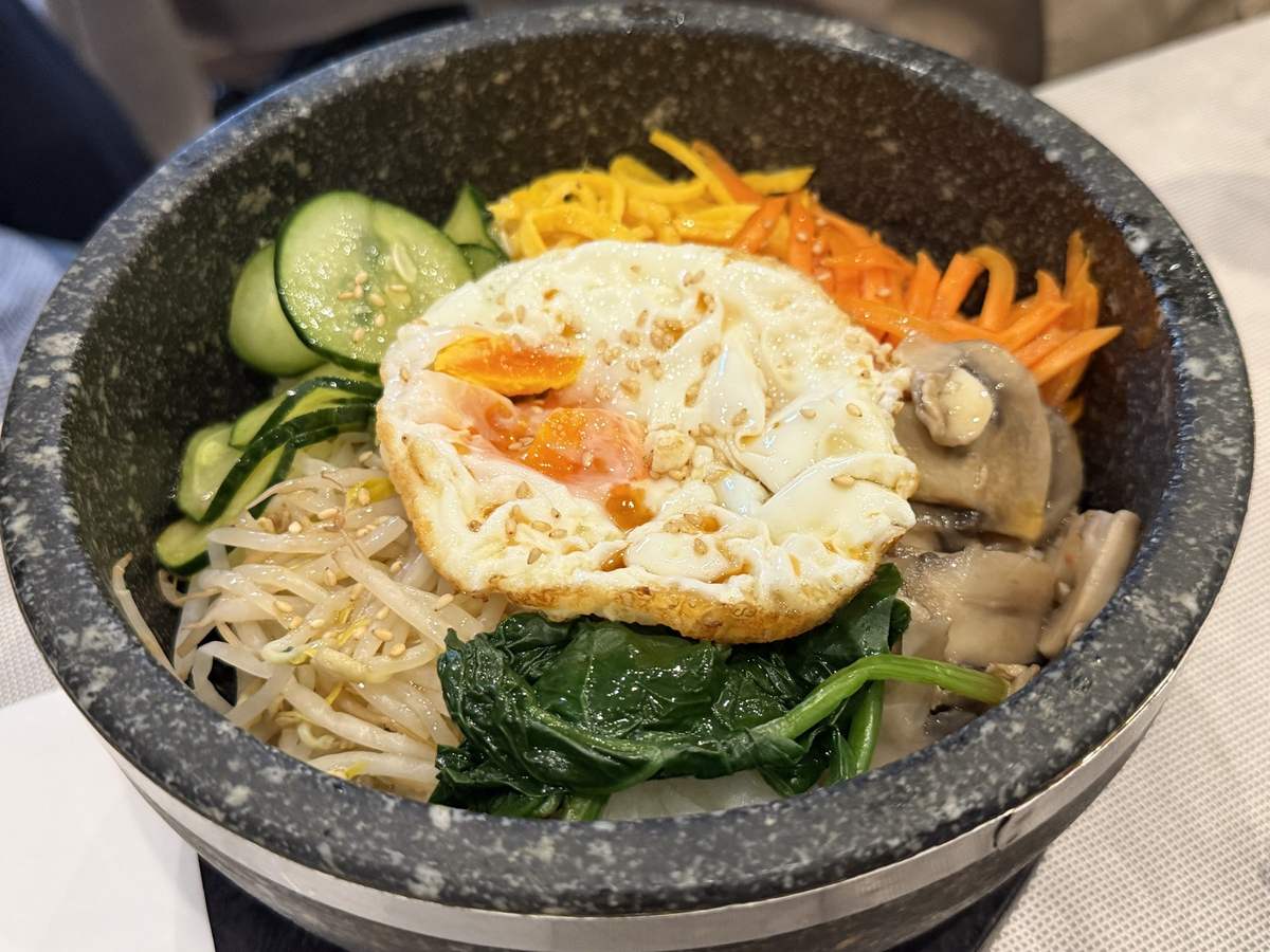 Dolsot bibimbap con uovo nella ciotola di pietra