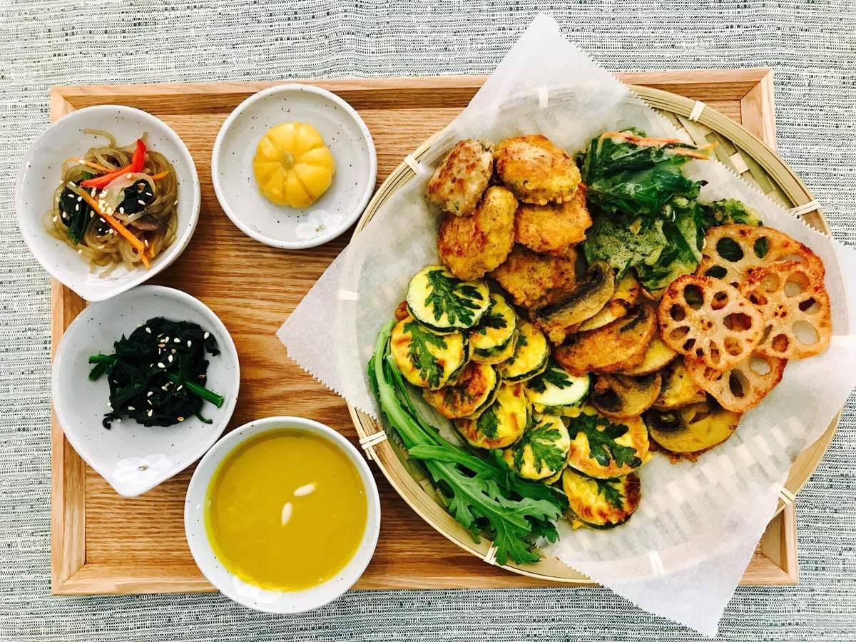 Vassoio con jeon misti, spinaci, kimchi e zuppa di zucca
