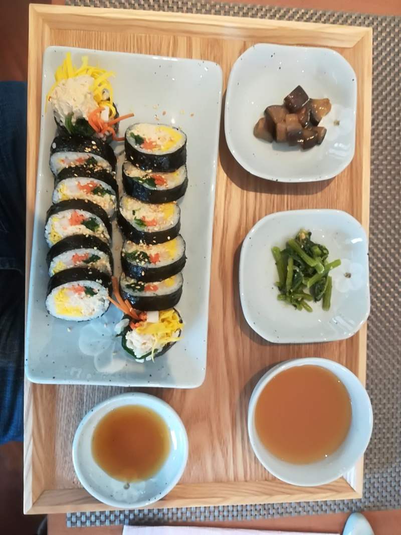 Kimbab su vassoio di legno con banchan e salse