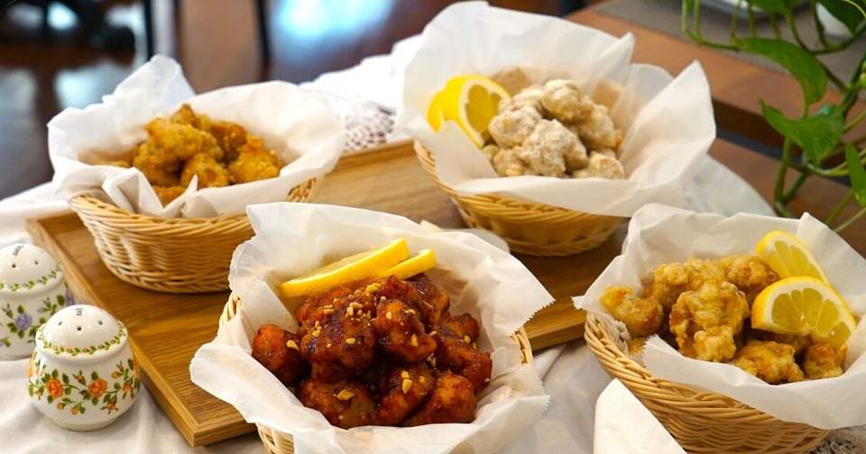 Quattro cestini di pollo fritto alla coreana con limone su tovaglia bianca di pizzo, al Dream