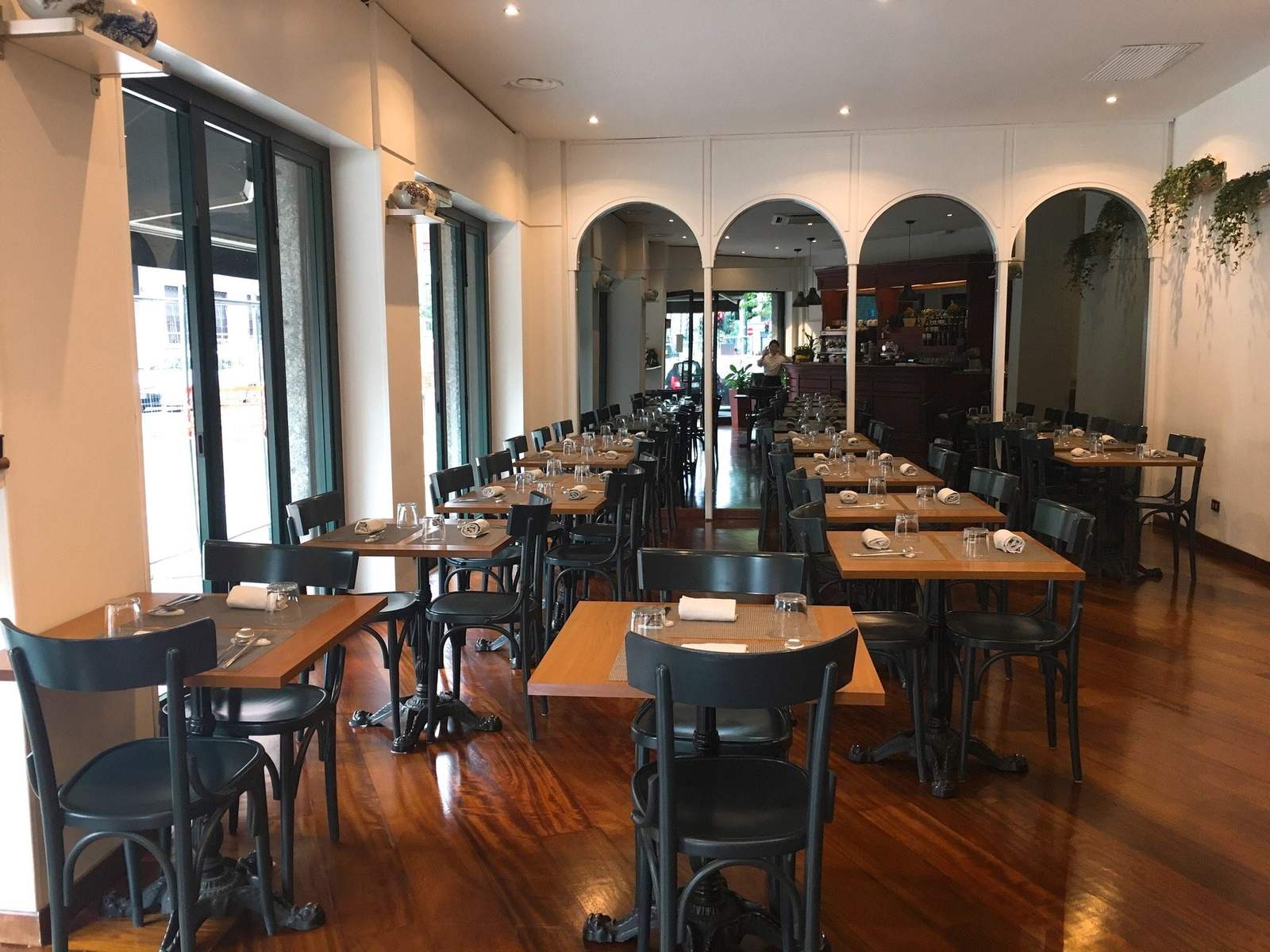 La sala del Dream con tavoli di legno, sedie nere e archi bianchi