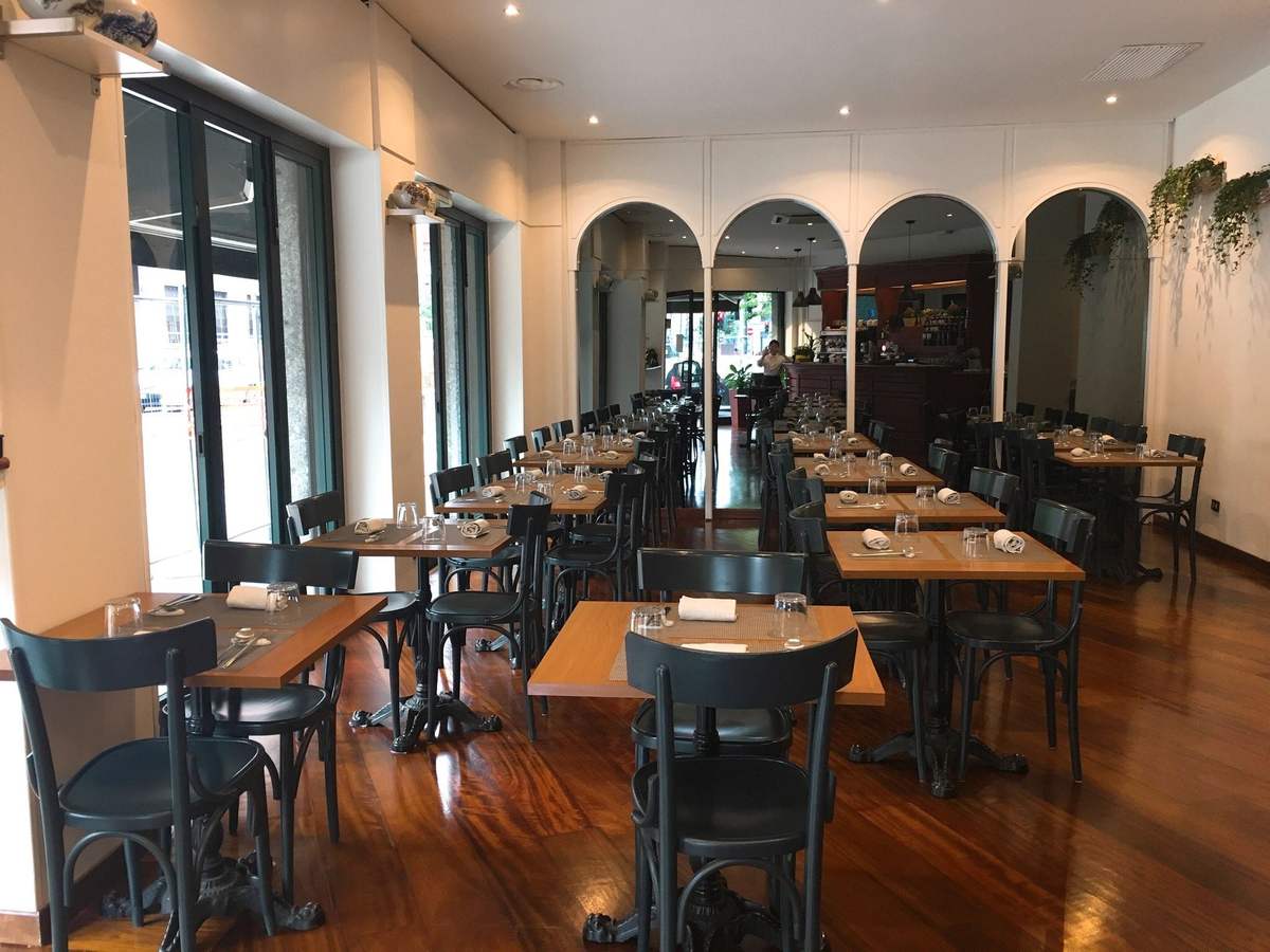 La sala del Dream con tavoli di legno, sedie nere e archi bianchi