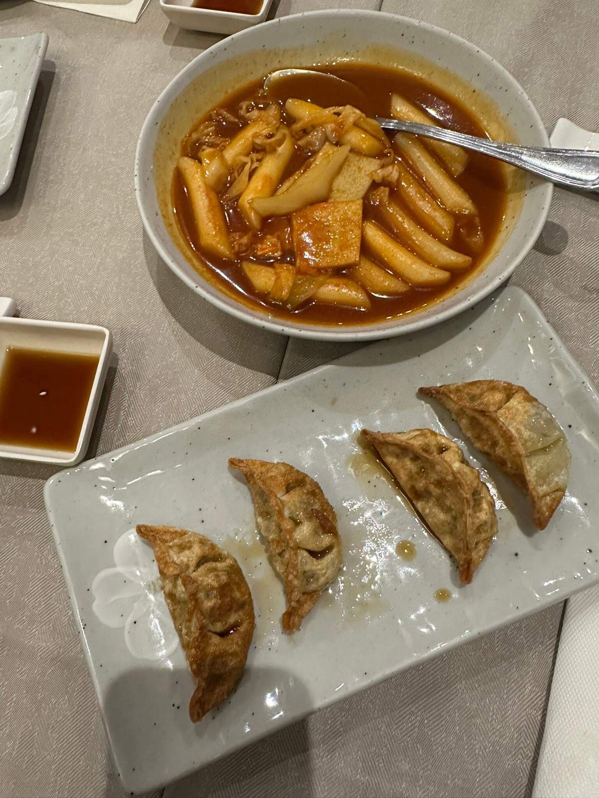 Tteokbokki in salsa piccante e gun mandu, ravioli fritti, su un tavolo del Dream